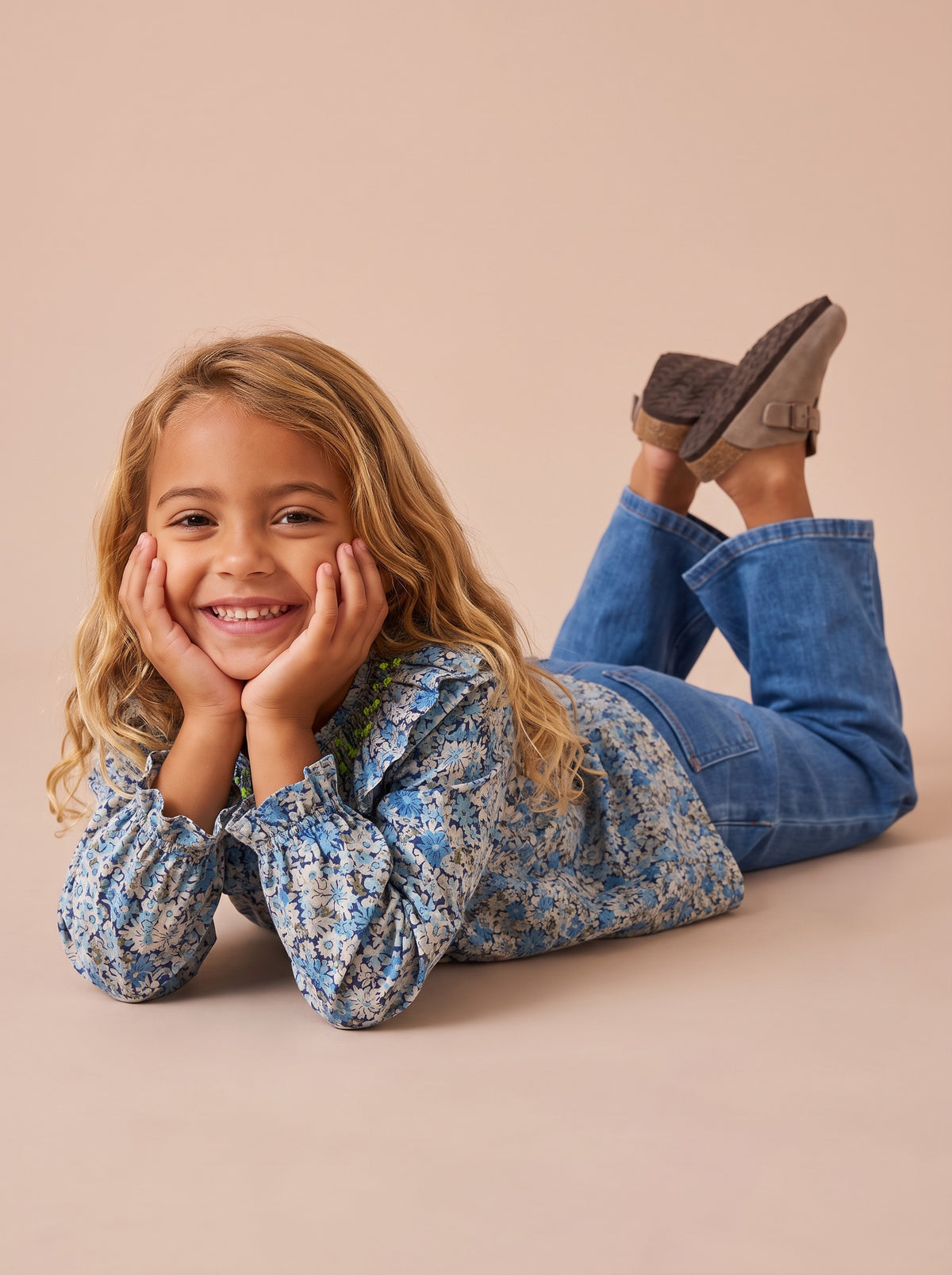 Blouse Rio bleu clair portée par une petite fille allongée, menton dans les mains