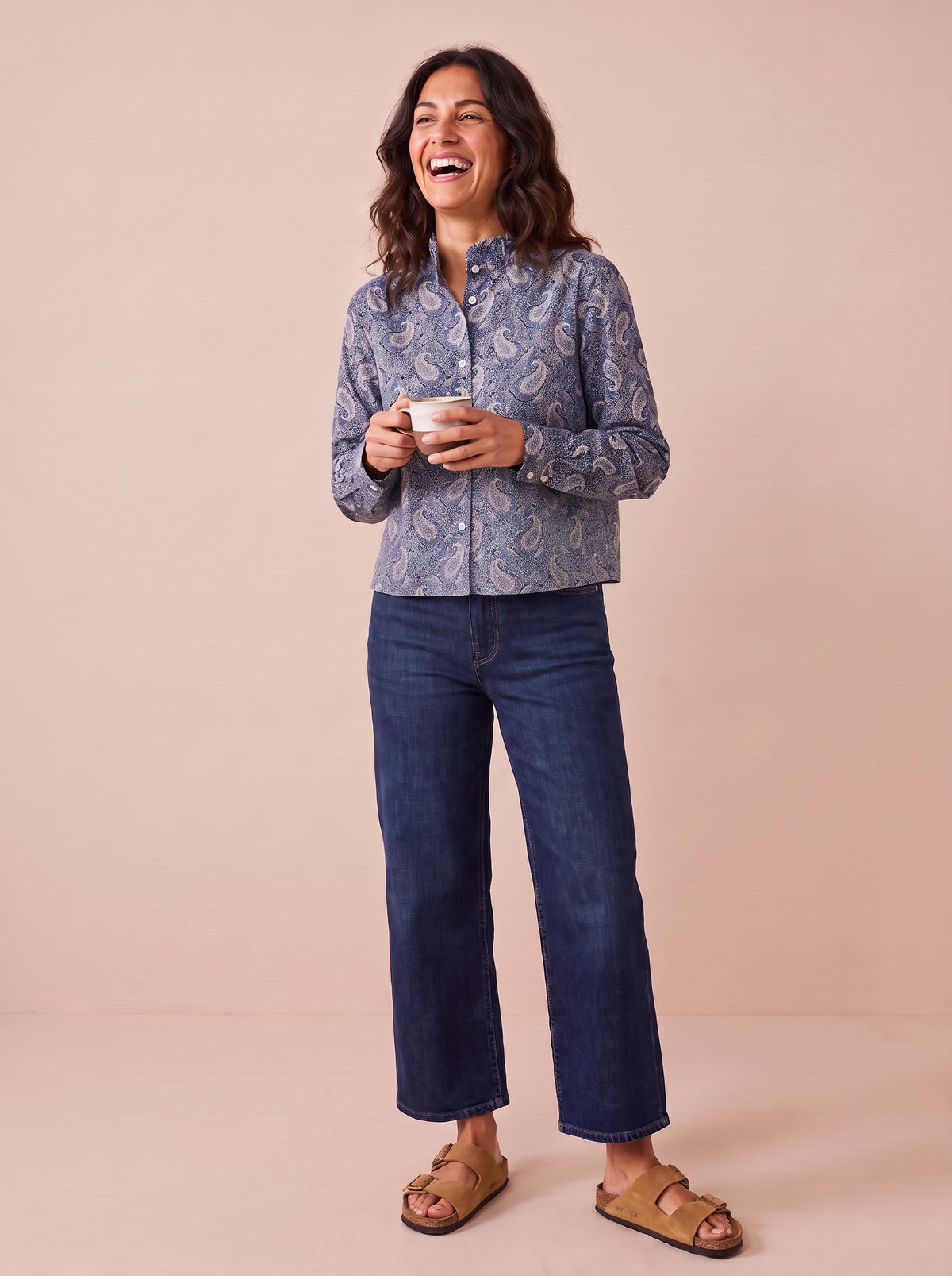 Chemise Zéli cachemire bleu portée avec un jean brut large, tasse de café à la main