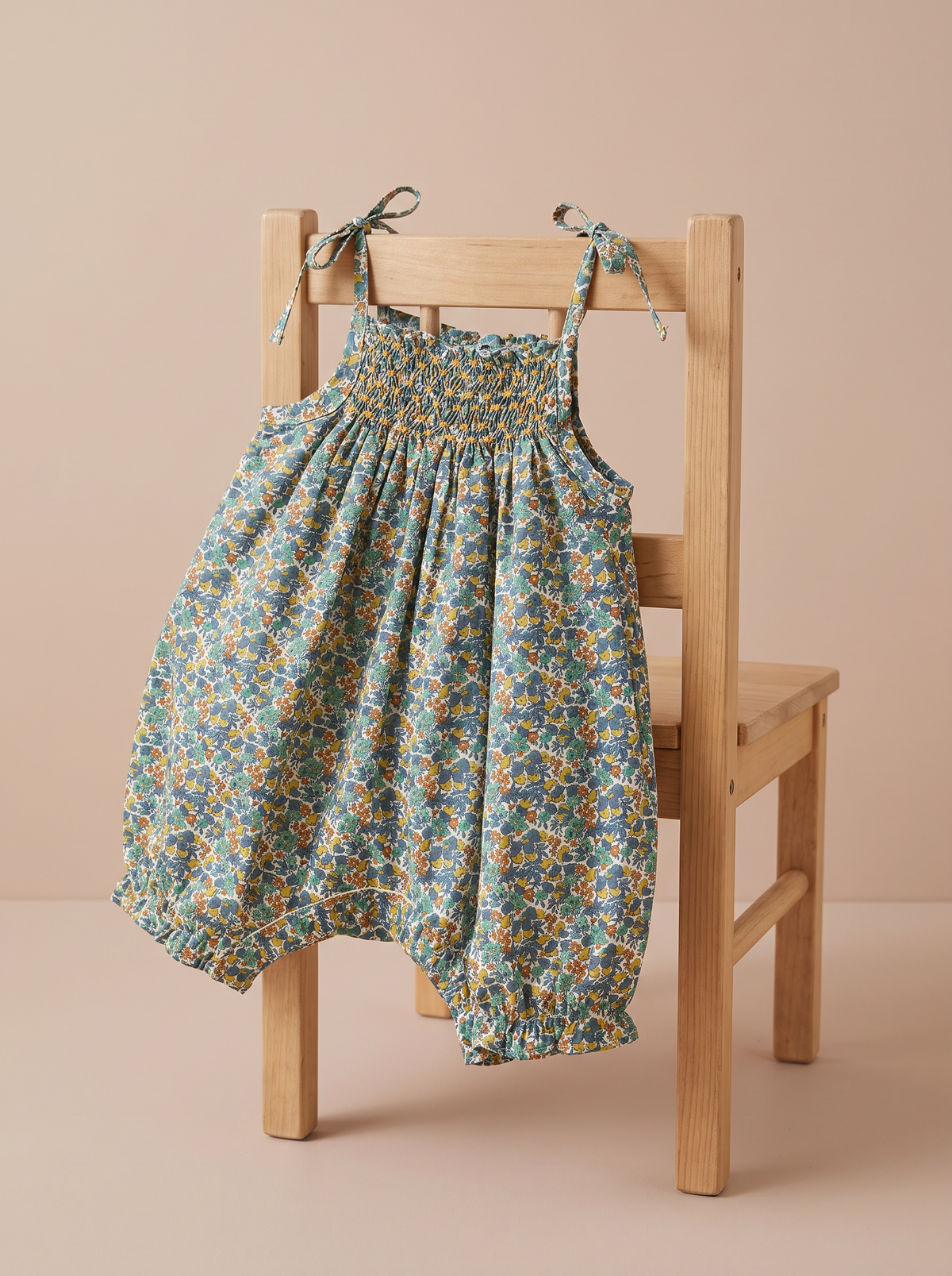 Combi Kami Pine green posée sur une petite chaise