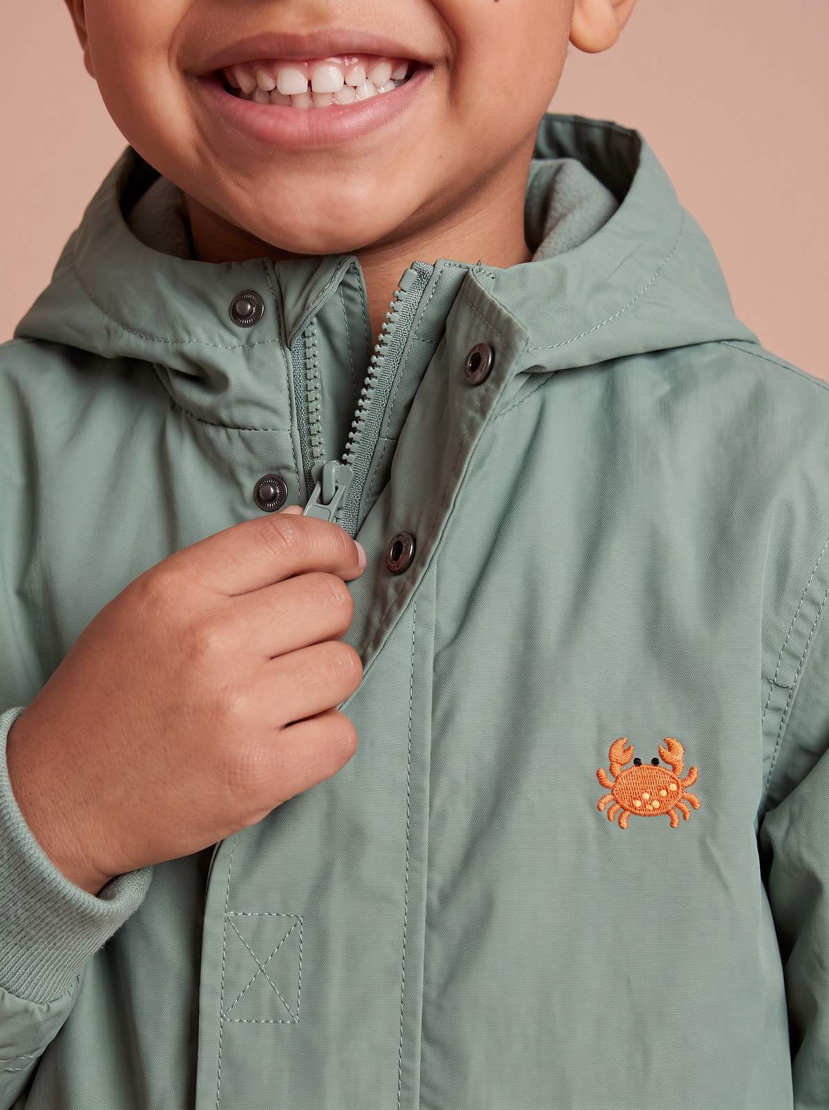 Imperméable vert sauge - zoom sur le crabe brodé